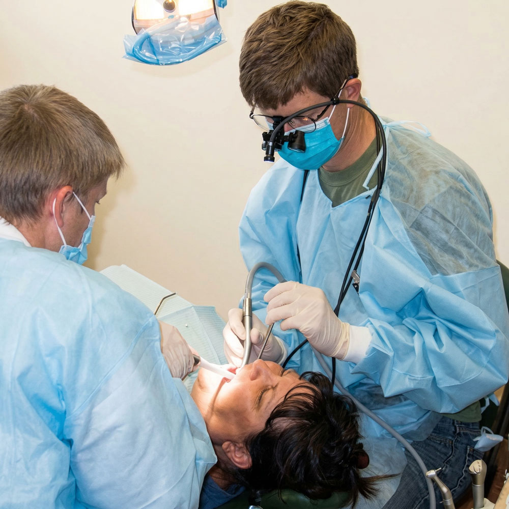 Two volunteer dental practitioners providing free care at Food & Care Coalition in Provo, Utah